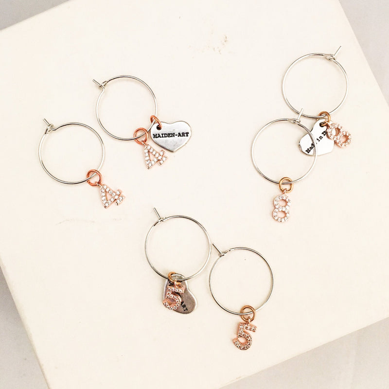 Number hoop earrings in silver, rose gold and rhinestones.